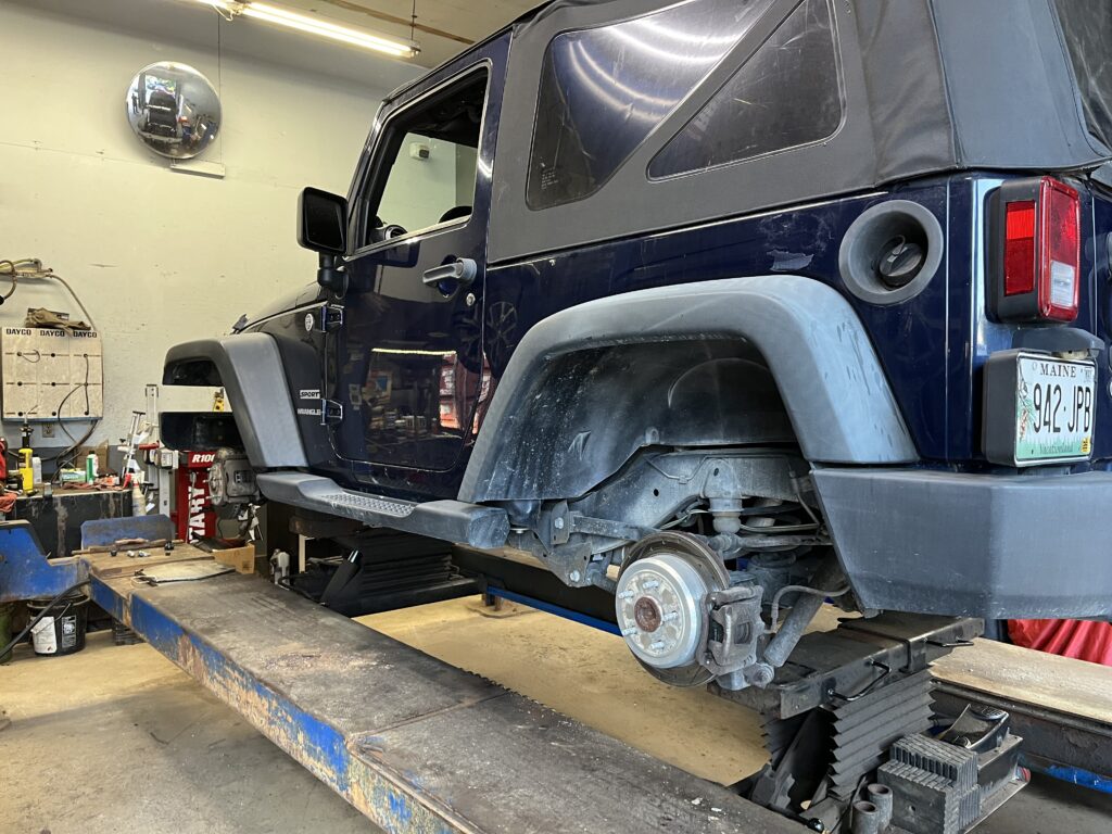 A jeep on a lift with no wheels